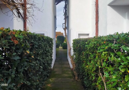Villetta a schiera residenziale con vialetto in pietra e accesso al cortile interno